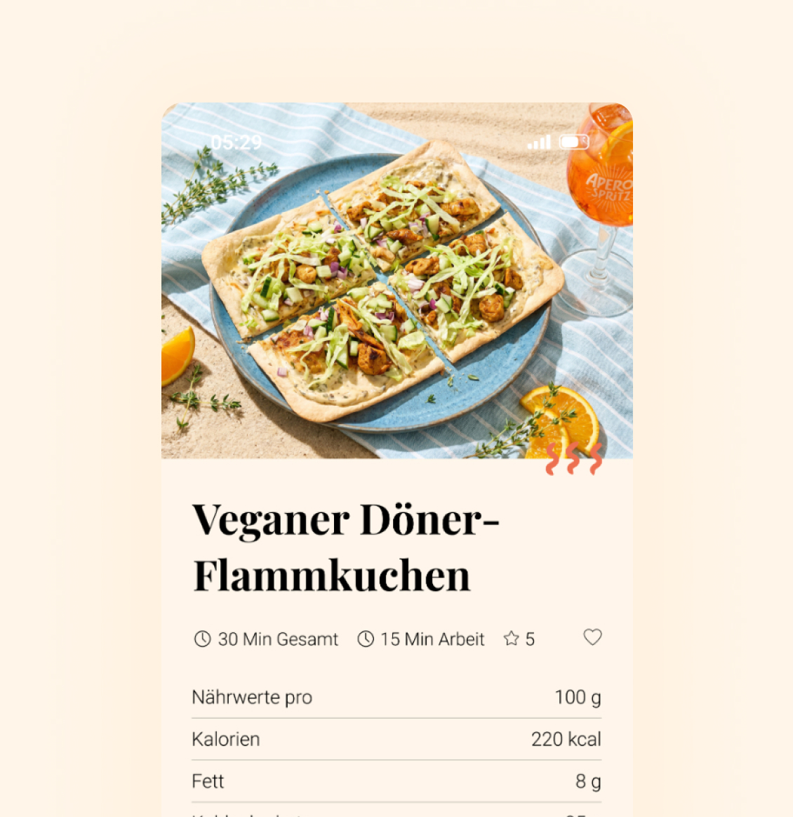 Veganer Döner‑Flammkuchen auf einem blauen Teller, in vier Stücke geschnitten, belegt mit veganen Dönerstücken, fein geschnittenem Salat, Gurkenwürfeln und Sauce.