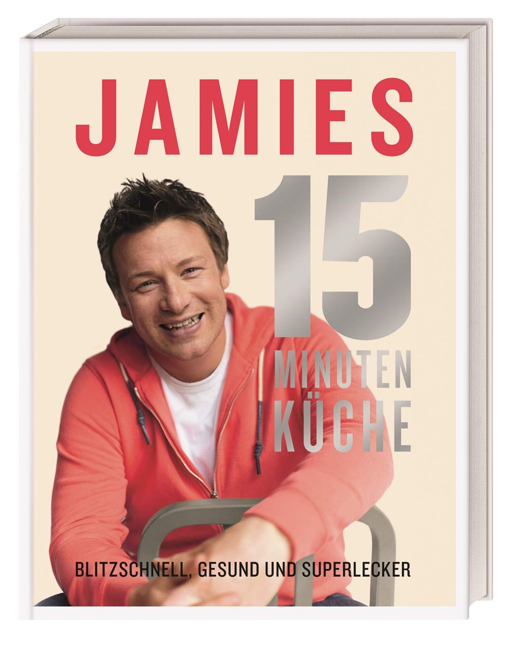 Das Bild zeigt das Cover des Kochbuchs "Jamies 15 Minuten Küche". Es zeigt den Titel in großen roten Buchstaben, den Namen "Jamie" und eine Beschreibung, die auf schnelle, gesunde und leckere Rezepte hinweist. Eine Person lächelt freundlich.