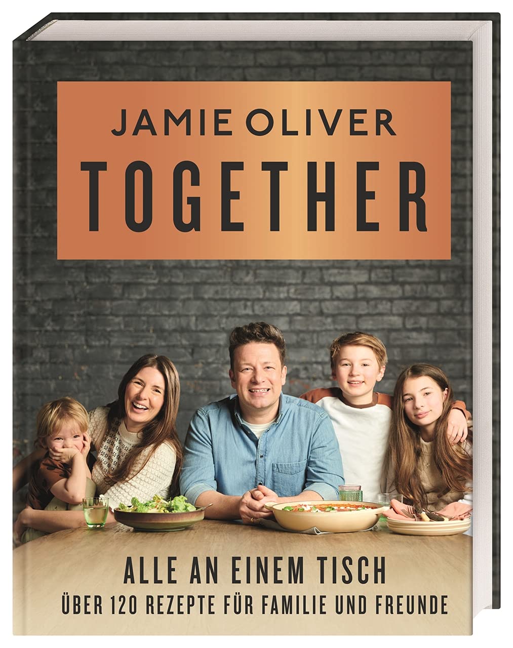 Das Bild zeigt das Cover eines Kochbuchs von Jamie Oliver mit dem Titel "Together". Es zeigt einen Tisch mit einem Familienessen und vier lächelnden Personen: einem Erwachsenen und drei Kindern. Der Titel und der Untertitel heben die Idee des gemeinsamen Essens hervor.