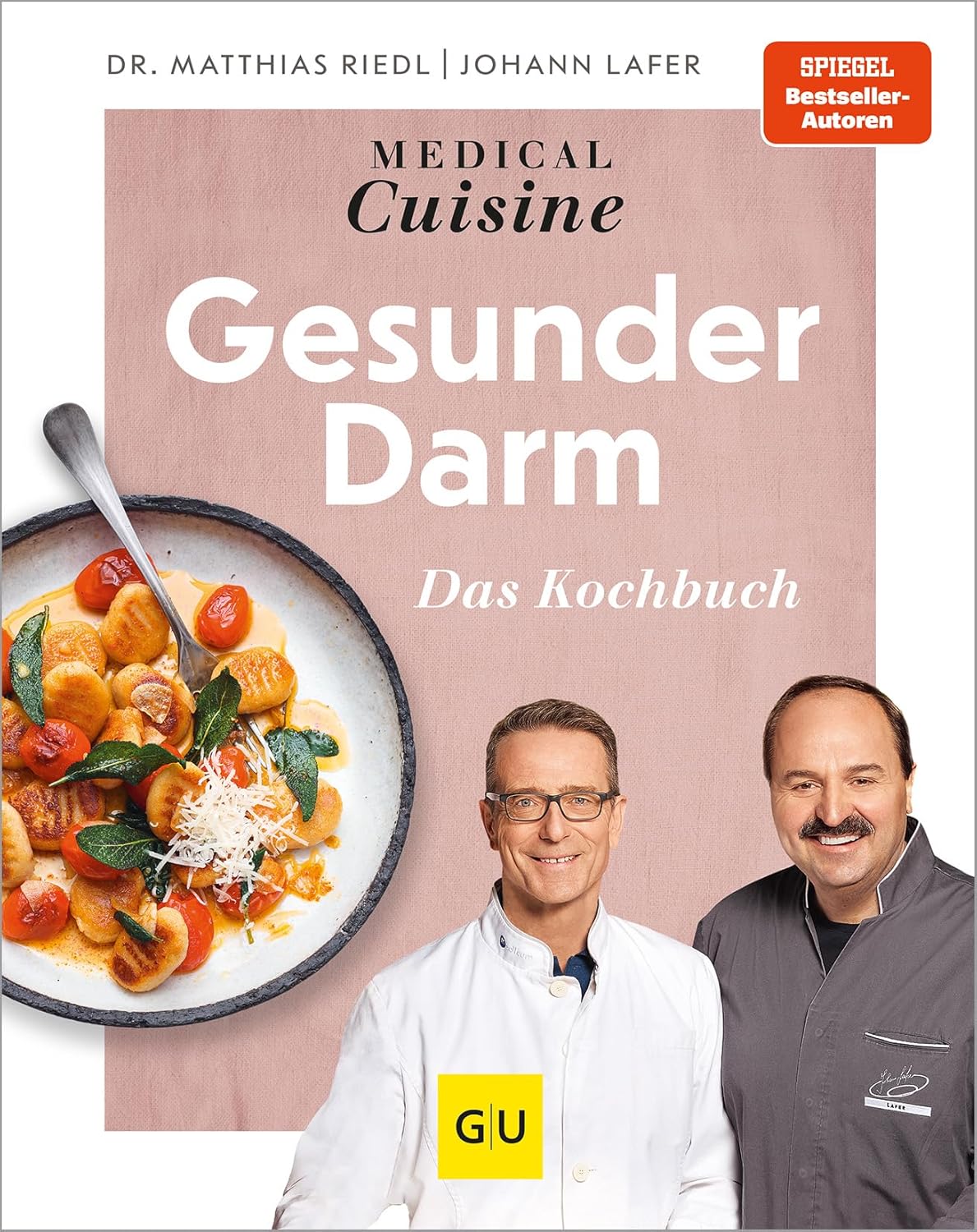Das Cover des Kochbuchs "Gesunder Darm" zeigt eine Schüssel mit Gnocchi, Tomaten und frischen Kräutern. Darunter ist der Titel des Buches auf rosa Hintergrund zu sehen. Neben der Schüssel stehen zwei Autoren, die in Kochjacken gekleidet sind.