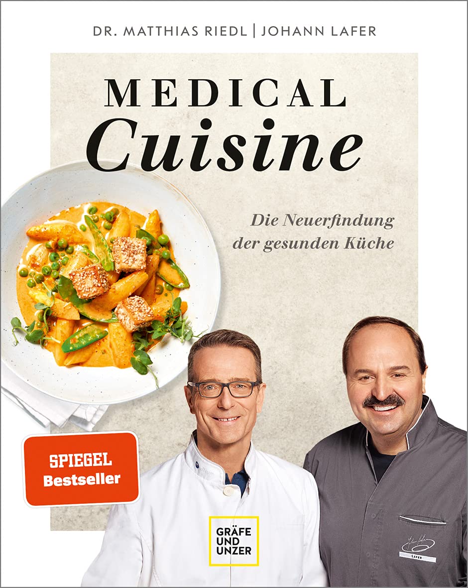 Auf dem Cover eines Buchs stehen die Titel „Medical Cuisine“ und „Die Neuentdeckung der gesunden Küche“. Im Vordergrund ist ein Teller mit einem bunten Gemüsegericht zu sehen. Zwei Autoren, ein Mann in einem weißen Kochmantel und ein weiterer Mann in grauer Kochbekleidung, lächeln in die Kamera.