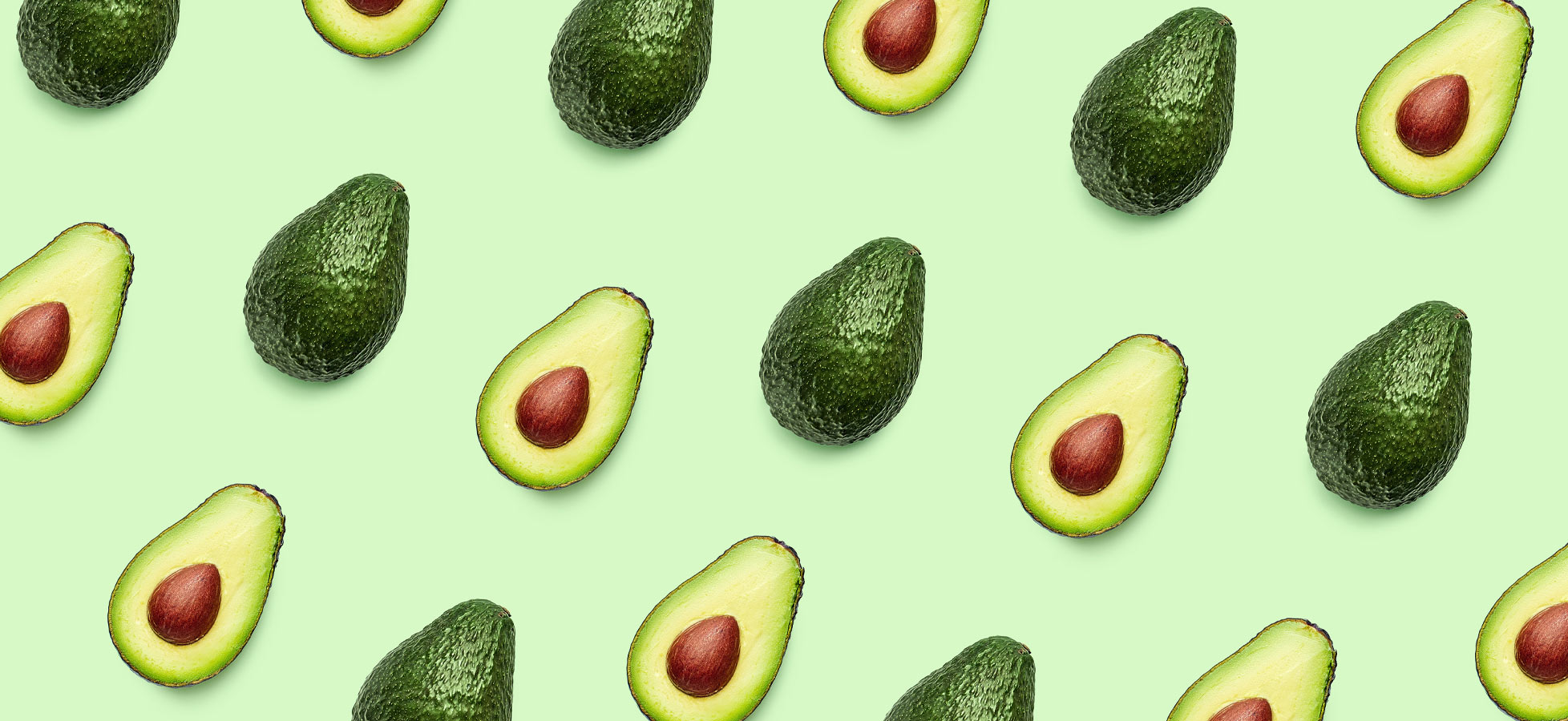 Eine gleichmäßige Anordnung von Avocados auf einem hellgrünen Hintergrund. Einige Avocados sind ganz, während andere halbiert sind, wobei die braunen Kerne sichtbar sind. Die Frucht ist in verschiedenen Positionen dargestellt.