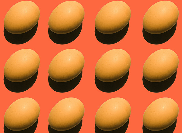 Die Abbildung zeigt mehrere gut platzierte, ovale, orangefarbene Eier auf einem leuchtend orangefarbenen Hintergrund. Jedes Ei wirft einen kleinen Schatten, was eine dreidimensionale Wirkung erzeugt. Die Anordnung ist regelmäßig und symmetrisch.