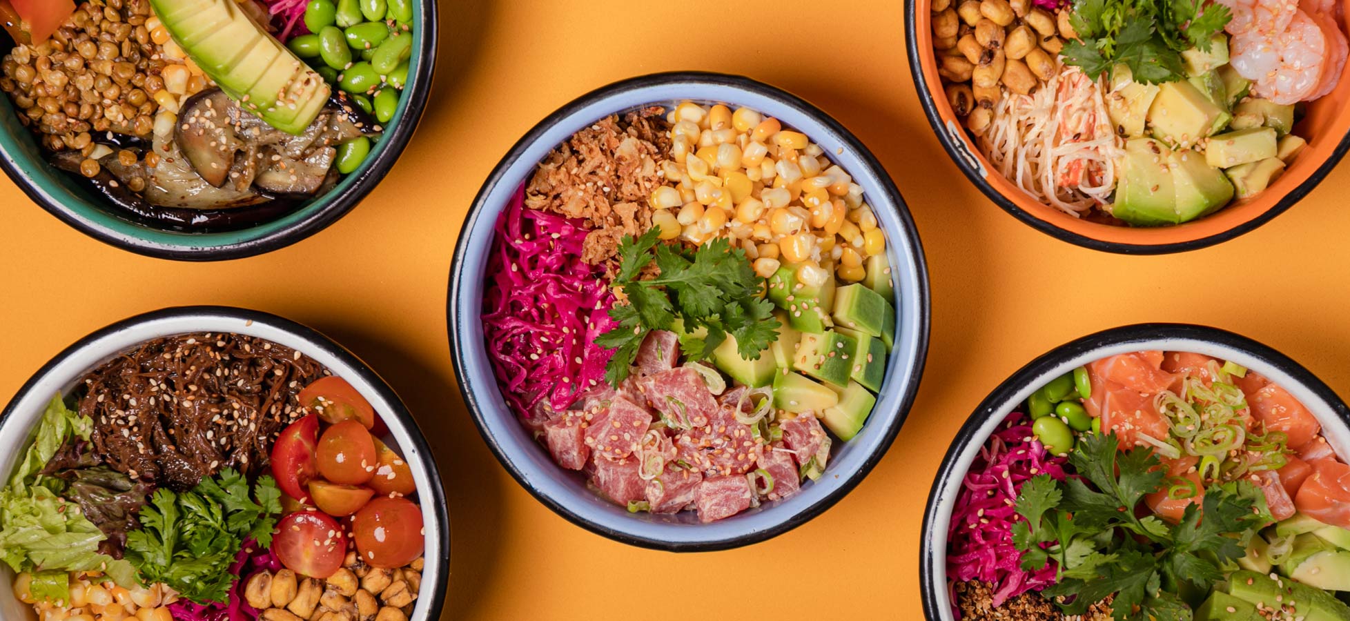 Fünf bunte Schalen mit verschiedenen Zutaten, darunter Gemüse, Obst, Tofu, Fisch und Kräuter, angeordnet auf einem orangefarbenen Hintergrund. Jede Schale bietet eine vielfältige Kombination, die Appetit anregt und gesund aussieht.