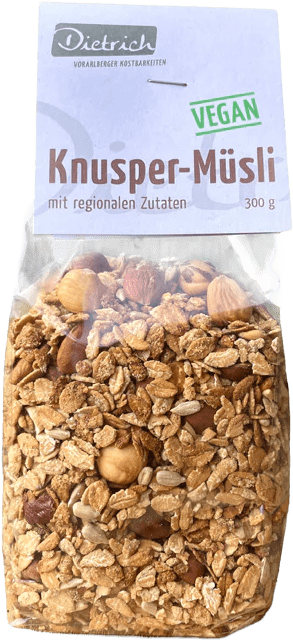 Tüte mit Knusper-Müsli, vegan, 300 g. Das Müsli besteht aus Haferflocken, Nüssen und anderen regionalen Zutaten. Auf dem Verpackungsetikett steht „Knusper-Müsli“ und „vegan“.