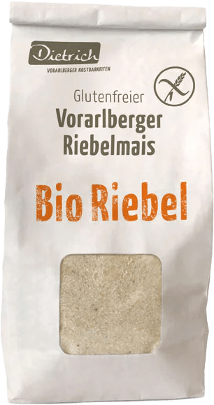 Ein Papiersack mit der Aufschrift "Glutenfreier Vorarlberger Riebelmais" und "Bio Riebel" in orange. Der Sack ist Teil der Marke Dietrich, die sich auf regionale Kost spezialisiert hat. Die Verpackung betont die glutenfreie Natur des Produkts.