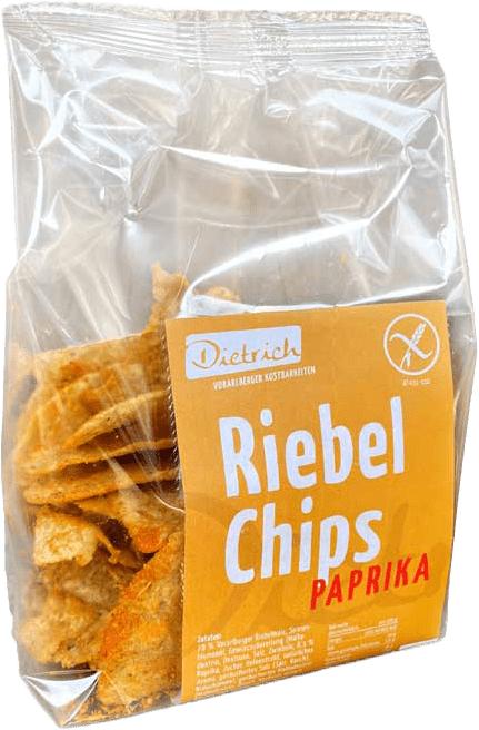 Eine Tüte Riebel Chips mit Paprika-Geschmack. Die Verpackung ist transparent, sodass die Chips sichtbar sind. Auf dem Etikett befindet sich der Schriftzug „Dietrich“ sowie der Hinweis „Riebel Chips Paprika“. Die Chips haben eine knusprige Textur und sind in einer goldenen Farbe gehalten.