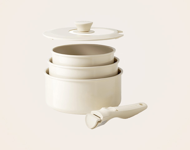 Ein Set aus drei ineinander gestapelten, hellen Kochschalen mit einem passenden Deckel. Eine der Schalen ist größer und hat einen flachen Griff, während die anderen beiden kleinere Schalen innen liegen. Sie sind ideal zum Kochen oder Servieren von Speisen.
