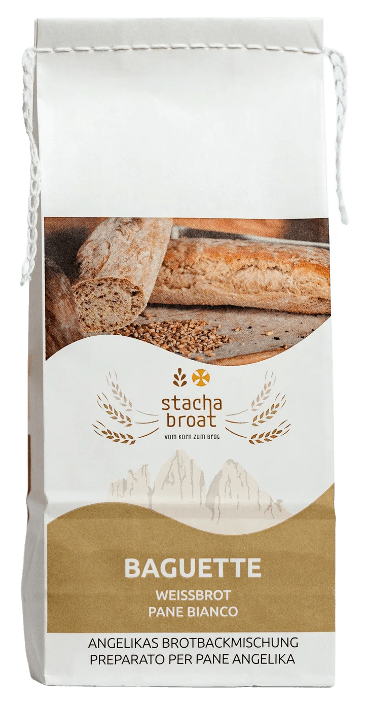 Eine Verpackung für Baguette-Backmischung. Auf dem Beutel steht „stacha broat“ und „BAGUETTE WEISSBROT“. Die Mischung ist für die Zubereitung von Weißbrot gedacht. Es sind auch Bilder von Brot und Körnern zu sehen.