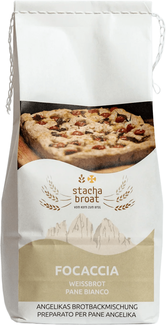 Eine Packung mit Focaccia Brotbackmischung. Auf der Vorderseite sind die Worte „Focaccia“ und „Weißbrot“ sowie das Logo „stacha broat“ abgebildet. Im Hintergrund ist ein Stück Focaccia mit Kirschtomaten und Kräutern zu sehen.