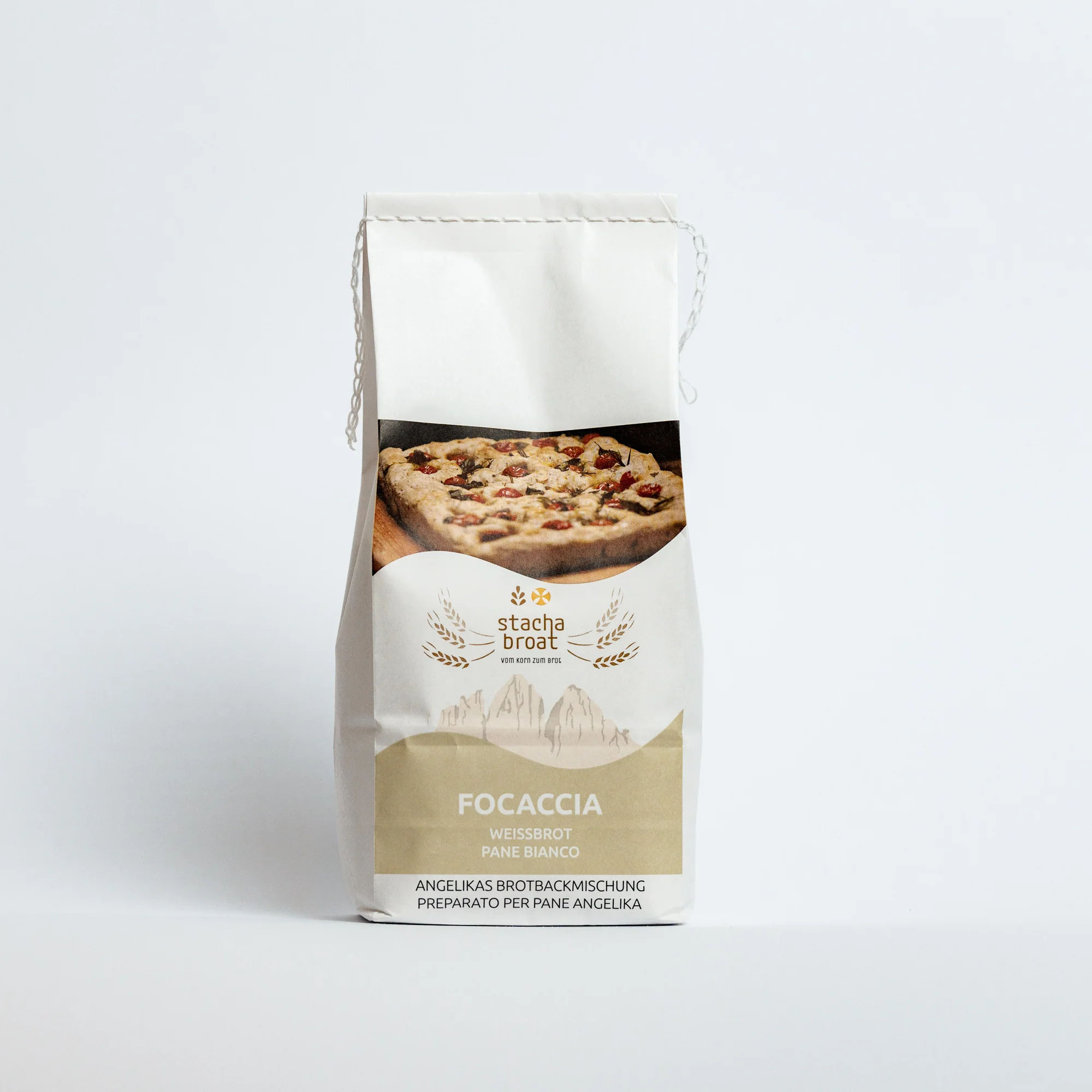 Eine weiße Verpackung für Focaccia-Brotmischung mit dem Aufdruck "Stacha Brot". Das Design zeigt ein Bild von Focaccia mit verschiedenen Zutaten. Unter dem Bild steht in klaren Buchstaben "Focaccia", "Weißbrot" und "Brotbackmischung".
