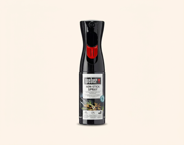 Das Bild zeigt eine Flasche Non-Stick Spray von Weber. Die Flasche ist schwarz mit einem roten Sprühkopf und enthält Informationen über das Produkt auf dem Etikett. Das Spray dient dazu, das Ankleben von Lebensmitteln beim Grillen und Kochen zu verhindern.