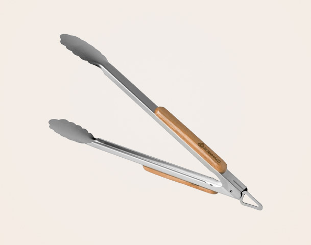 Edelstahl-Zange mit einem Holzgriff, ideal zum Wenden und Servieren von Speisen. Die Zange hat eine praktische Form mit gezahnten Enden, um einen sicheren Halt zu gewährleisten. Sie eignet sich für den Einsatz in der Küche und beim Grillen.
