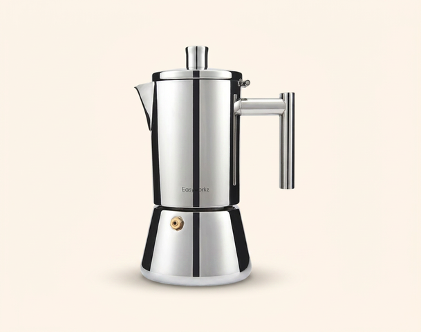 Eine glänzende, silberne Espressokanne aus Edelstahl steht auf einem hellen Hintergrund. Sie hat einen runden Boden, einen schmalen Körper und einen Ausguss mit einem abnehmbaren Deckel. Der Griff ist gut sichtbar und sorgt für eine ergonomische Handhabung.