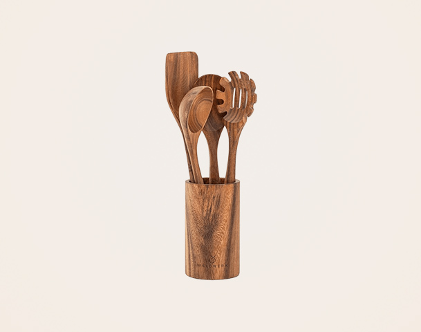 Über einem hellen Hintergrund steht ein zylindrischer Halter aus Holz, der mehrere Holzutensilien enthält. Dazu gehören ein Spatel, ein Löffel und ein Rührer. Alle Utensilien sind aus edlem Holz gefertigt und verleihen eine rustikale, warme Ausstrahlung.