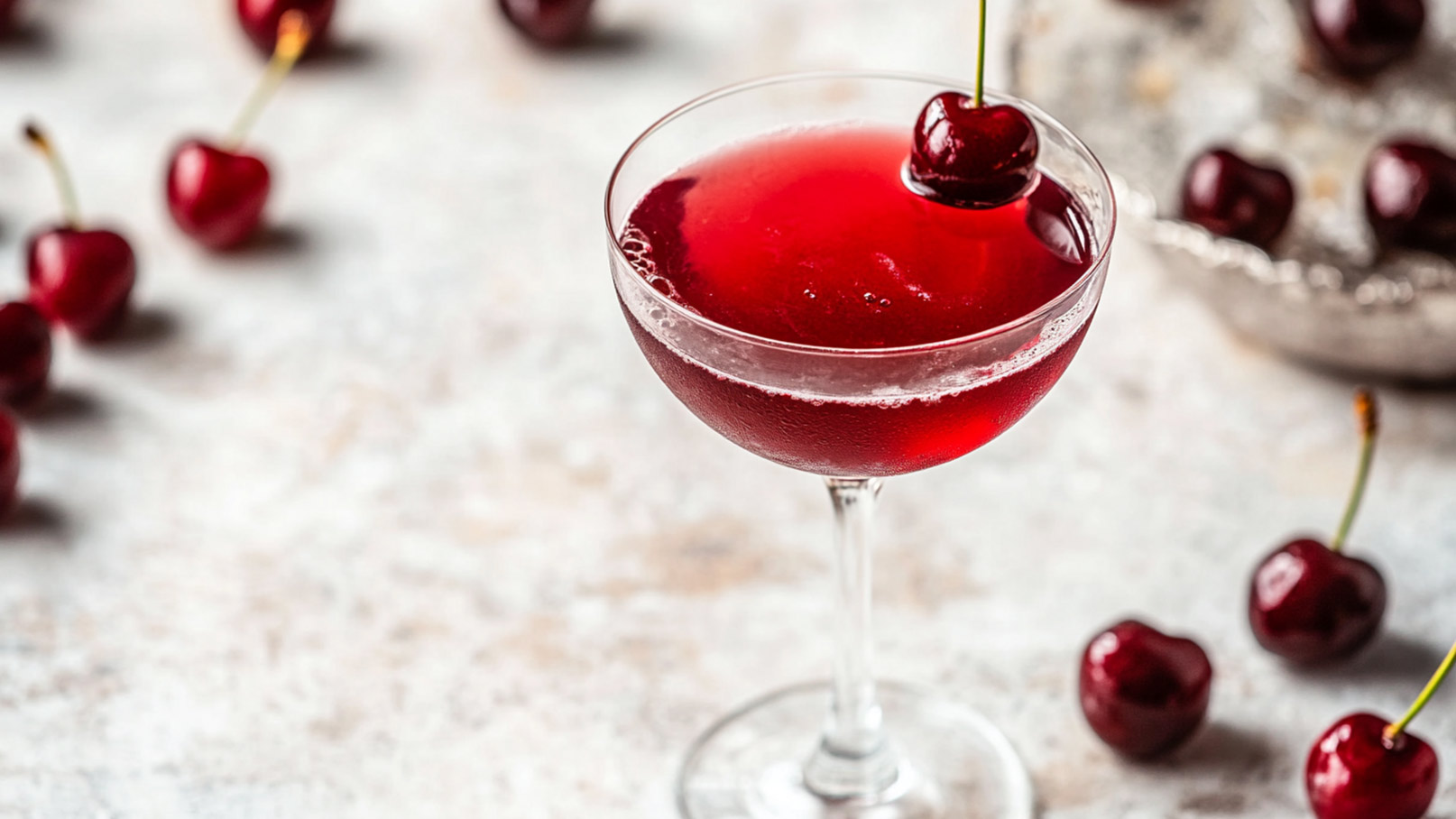 Das Bild zeigt zwei elegante Gläser, gefüllt mit köstlichem Kirschlikör. Im Hintergrund ist eine schwarze Flasche zu erkennen. Um die Gläser herum liegen viele frische Kirschen, die die Frische und den Geschmack des Likörs unterstreichen. Die tiefrote Farbe des Likörs und die glänzenden Kirschen lassen das Bild luxuriös und verlockend wirken.
