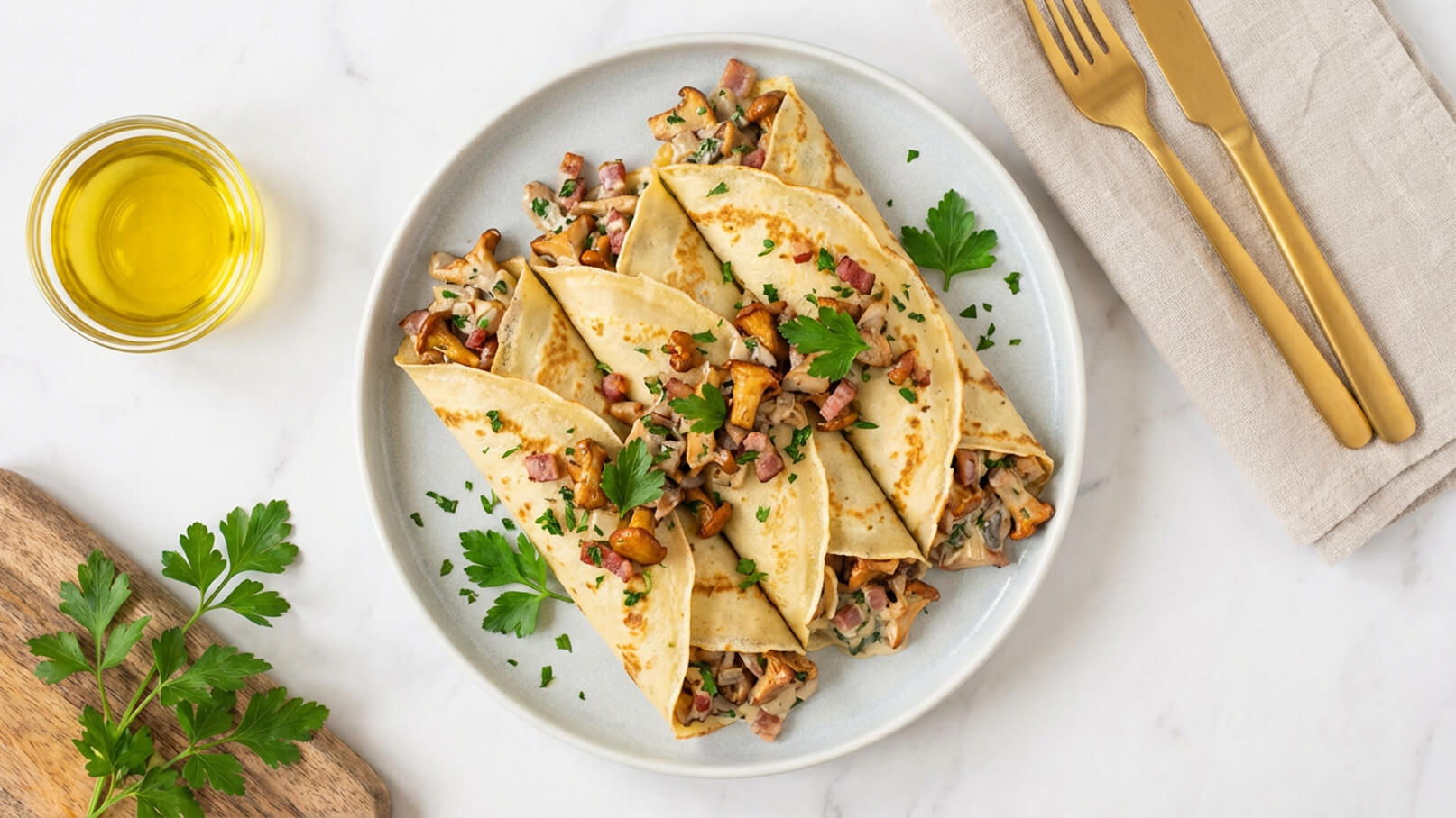 Auf dem Bild ist ein Teller mit gefüllten Pfannkuchen zu sehen, die mit Pilzen und Speck gefüllt sind. Die Pfannkuchen sind garniert mit frischer Petersilie. Daneben befindet sich ein Glas mit Olivenöl und eine Serviette mit Besteck.