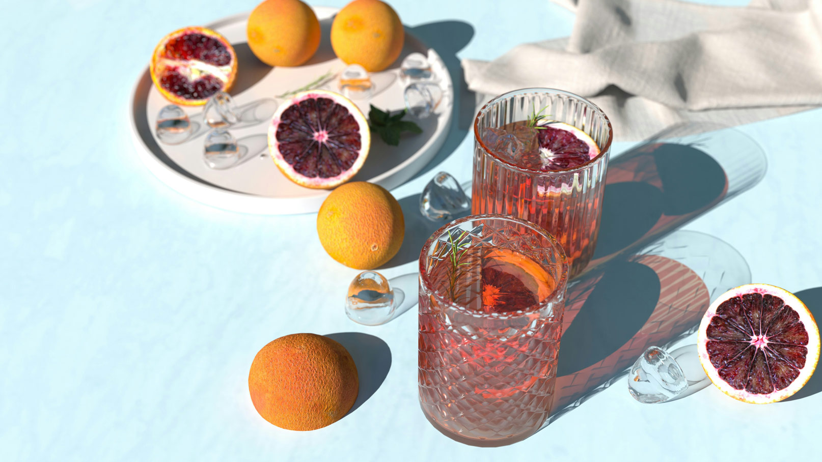 Zwei Gläser mit einem rosafarbenen Getränk, verziert mit einer Scheibe Blutorange, stehen auf einem hellen Tisch. Um die Gläser liegen frische Blutorangen und Eiswürfel. Ein weißes Tablett mit weiteren Blutorangen ist im Hintergrund sichtbar.