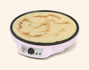 Ein elektrischer Crêpes-Maker in rosa Farbe zeigt eine goldbraun gebratene Crêpe auf der heißen Platte. Der Bedienknopf und zwei Kontrollleuchten sind an der Seite sichtbar.