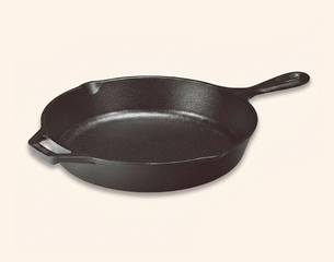 Gusseiserne Lodge-Bratpfanne mit gelb-schwarzem Etikett: „Seasoned Cast Iron Skillet“ und Angaben „PFAS free“, „Made in the USA“, „Pre-seasoned“.