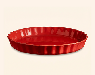 Rote, glänzende Keramik‑Tarteform mit flachem Boden und gewelltem, leicht erhöhtem Rand.