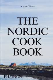 Das Bild zeigt das Buchcover „The Nordic Cook Book“ von Magnus Nilsson. Der Titel ist fett gedruckt und steht vor einer Landschaft mit Wasser und einem kleinen roten Haus im Hintergrund. Das Cover vermittelt ein Gefühl der nordischen Kulinarik.